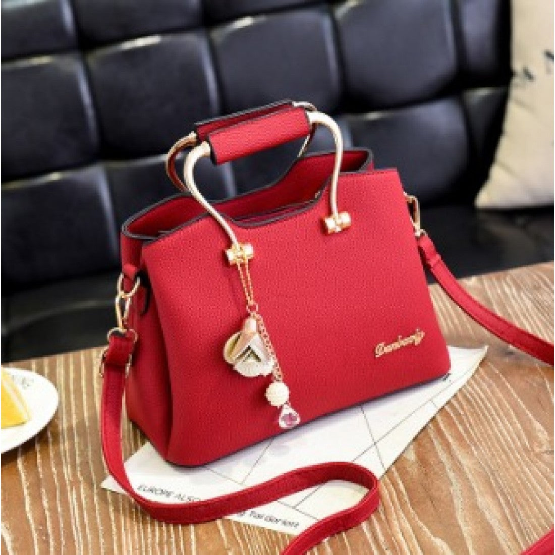 Elegant Handbag with Gold Handles and Charm Pendant
