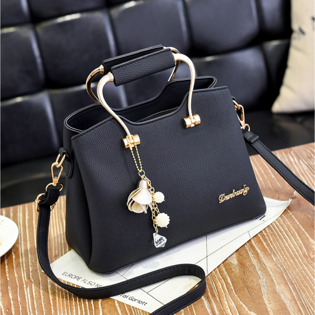 Elegant Handbag with Gold Handles and Charm Pendant